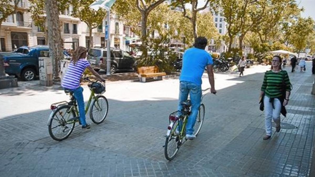 Unos ciclistas en la esquina del paseo de Sant Joan con Aragó.