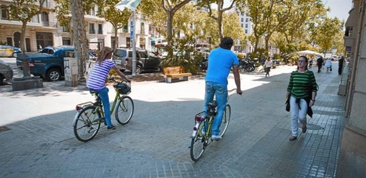 Uns ciclistes a la cantonada del passeig de Sant Joan amb Aragó.