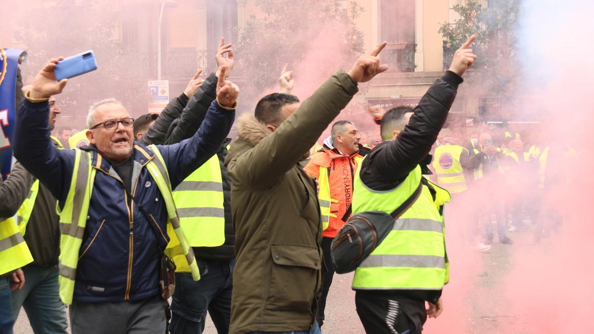 Manifestants de Sintraport criden i llencen bombes de fum davant la Delegació del Govern a Barcelona