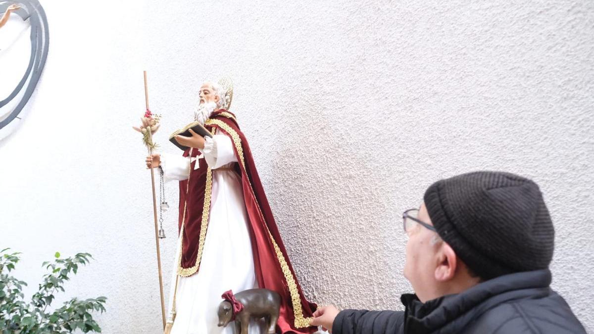 El párroco de San Antón muestra la imagen del santo recién restaurada