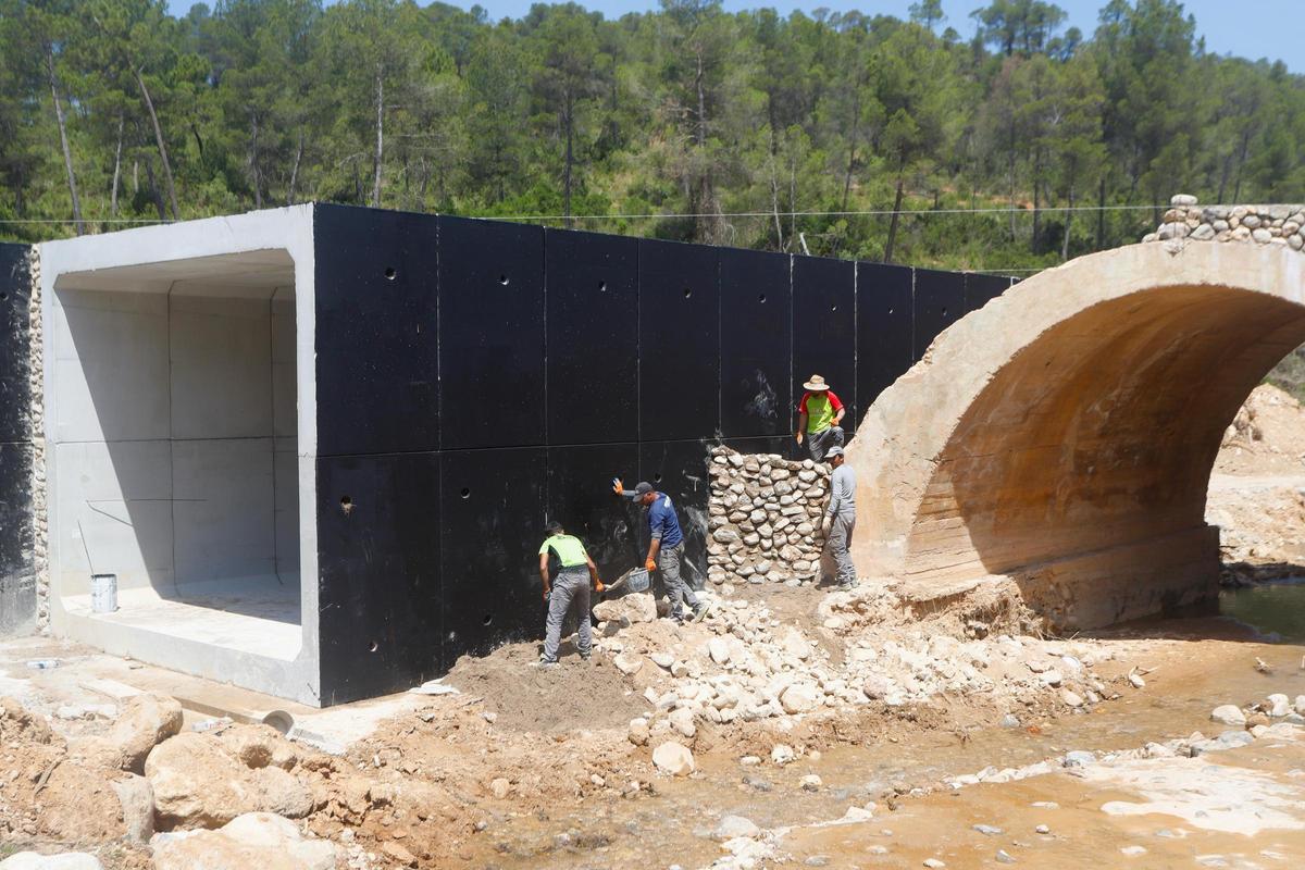 Trabajadores reconstruyendo un puente con bloques de hormigón provisionales