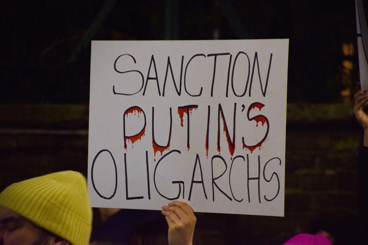 Un manifestante sostiene una pancarta, sancionar a los oligarcas de Putin, frente a la embajada rusa en Londres.