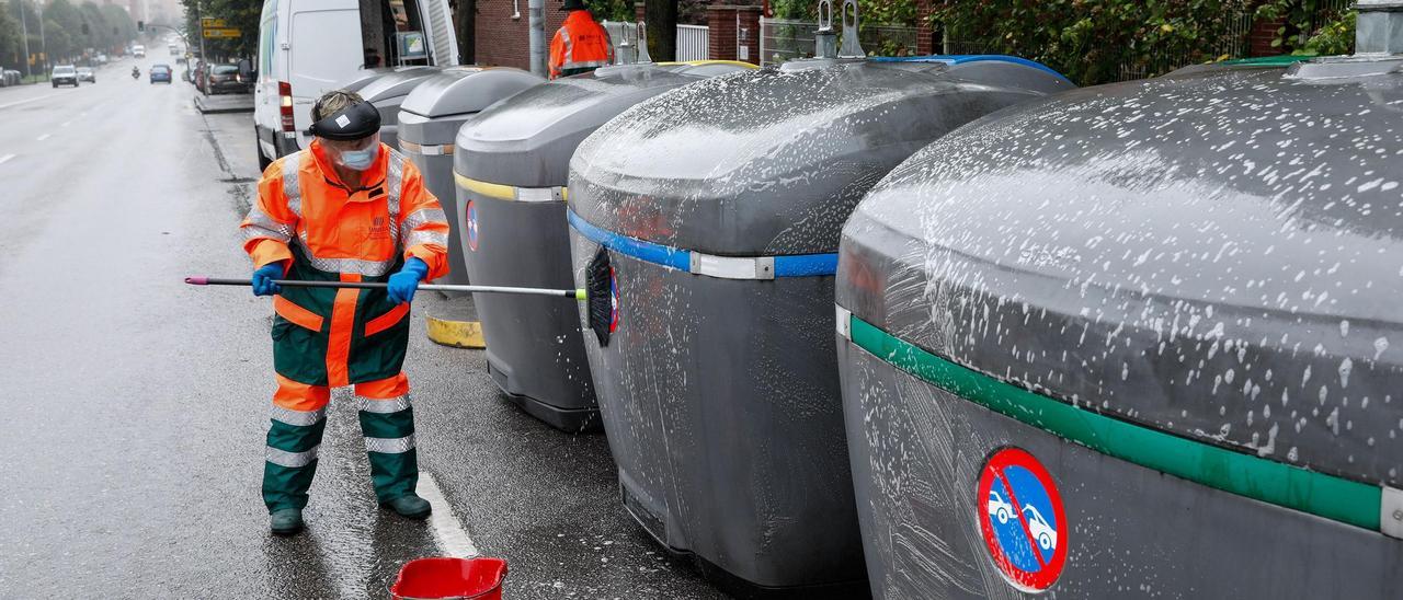 Un operario de Emulsa limpia contenedores de reciclaje