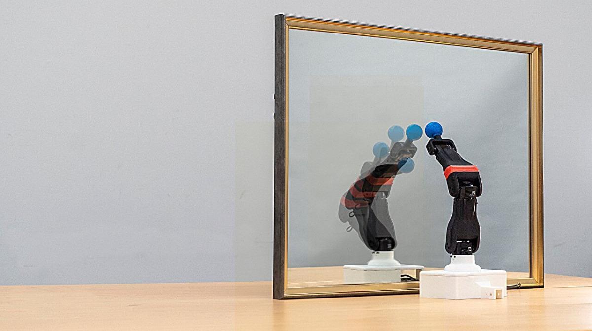 Un robot observa su reflejo en un espejo, aprendiendo su propia morfología y estructura de movimientos.