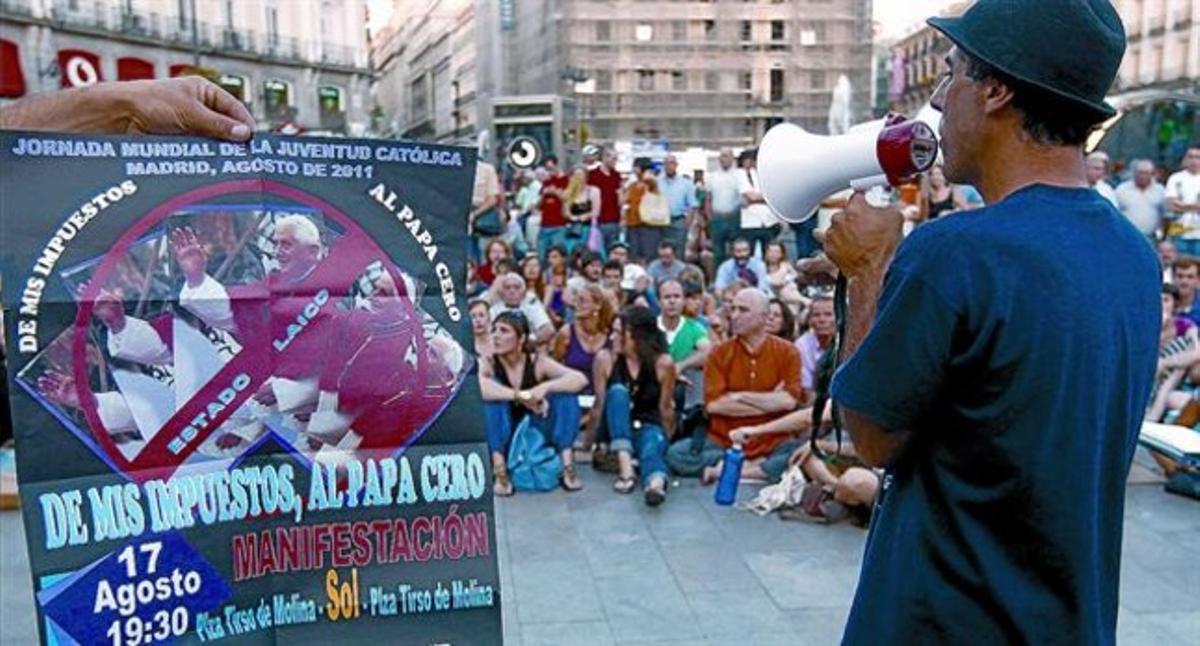 Un cartell crític amb la visita del Papa presidia ahir una assemblea d’indignats celebrada a la Puerta del Sol. Un cartell crític amb la visita del Papa presidia ahir una assemblea d’indignats celebrada a la Puerta del Sol.