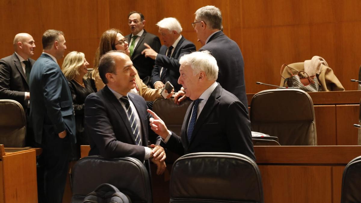 El consejero López conversa con el consejero Bancalero, al inicio del pleno de las Cortes.
