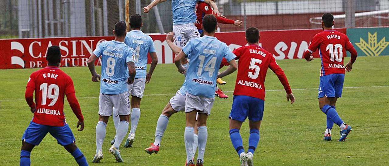 Rufo y Pelayo Suárez disputan un balón aéreo ante la mirada de sus compañeros. | Á. González