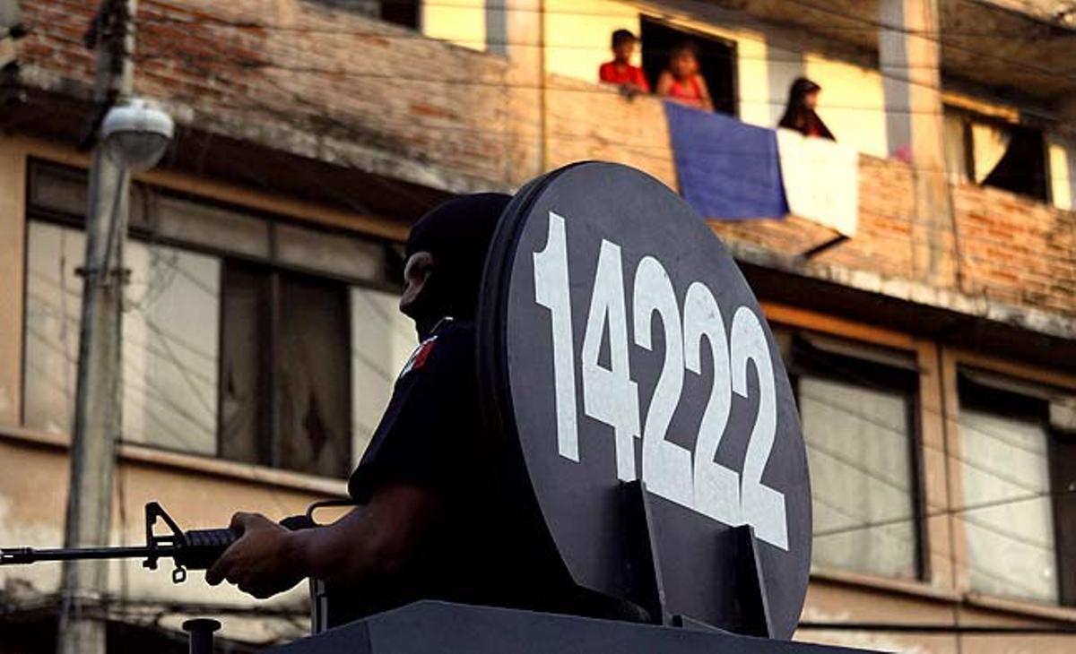 Un oficial de la policia federal fa guàrdia en un vehicle blindat a Cuernavaca (Mèxic).