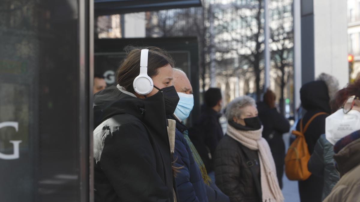 Un grupo de zaragozanos esperan para coger el autobús, todavía con la obligatoriedad de portar mascarilla.