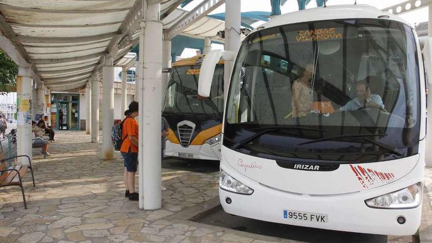 Pasajeros en la estación de Cangas, con un autobús que realiza la ruta por la costa. // G.Núñez