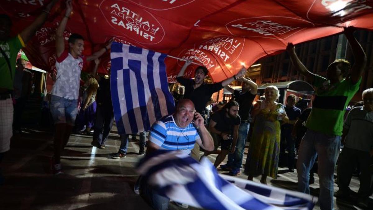 Un seguidor de Syriza celebra con banderas la victoria de su partido en 2015.