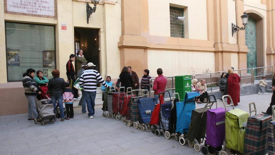 Una cola de carritos de la compra para coger comida en el comedor social de Cáritas en Cartagena.