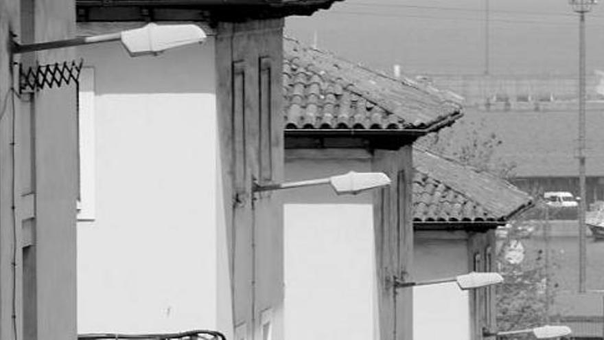 Las farolas que iluminan actualmente el barrio de Portuarios, con el puerto de El Musel al fondo.