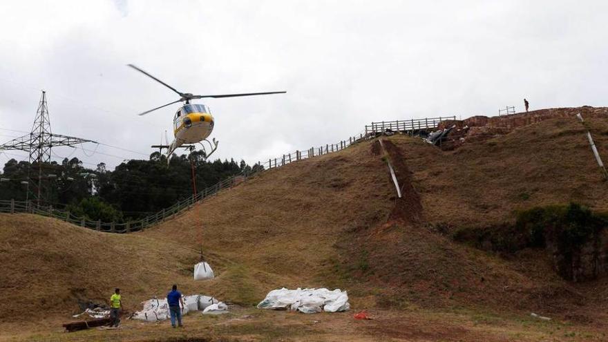 El helicóptero transportando material desde la base del Peñón de Raíces hasta el castillo de Gauzón.