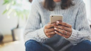 Una mujer consulta su teléfono móvil.