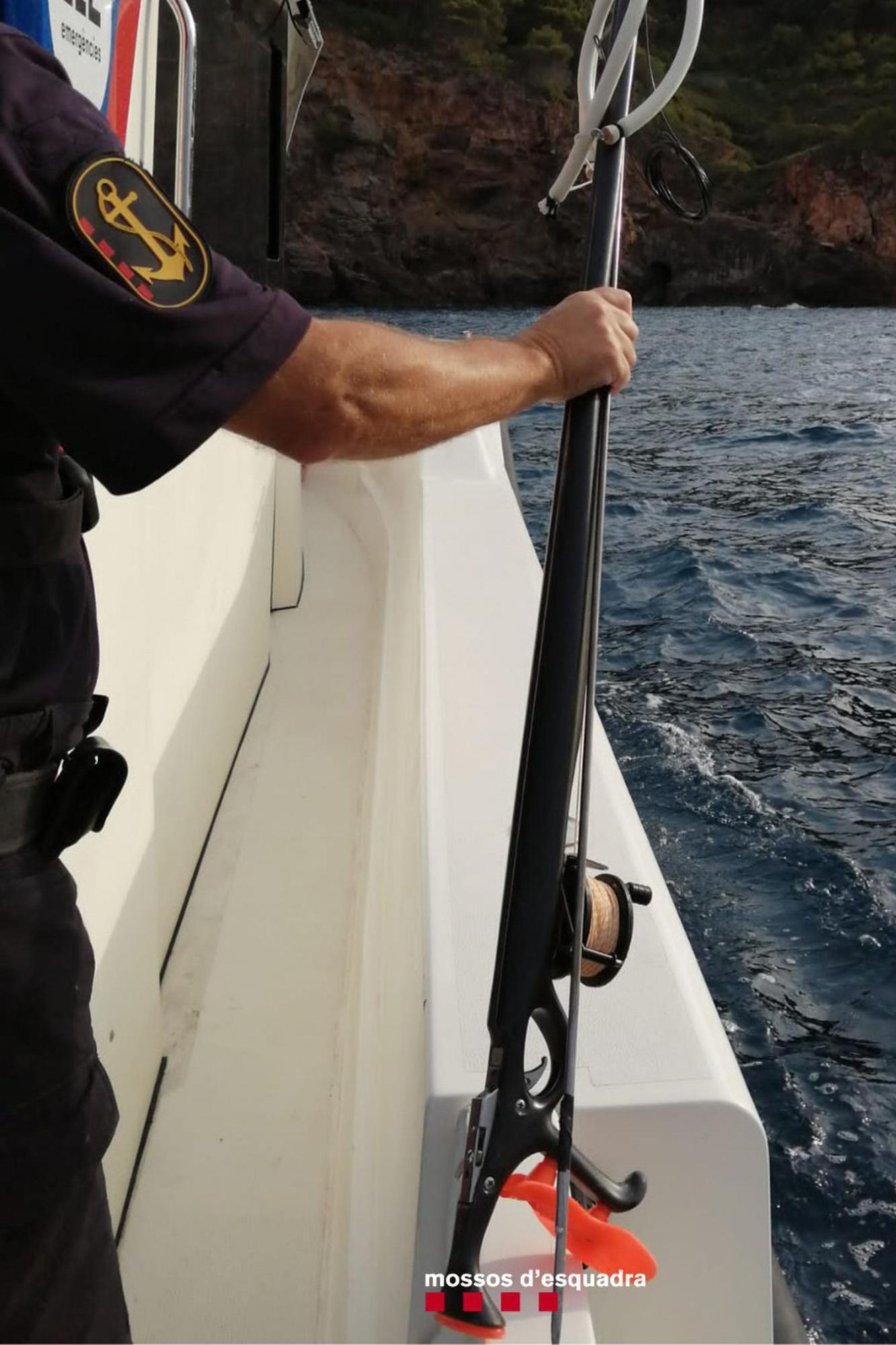 Un agent de la policia marítima dels Mossos d&#039;Esquadra aguanta un fusell que utilitzava un home per pescar en una reserva marina