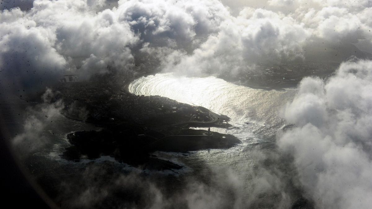 Imagen aérea de la Torre de Hércules entre nubes.