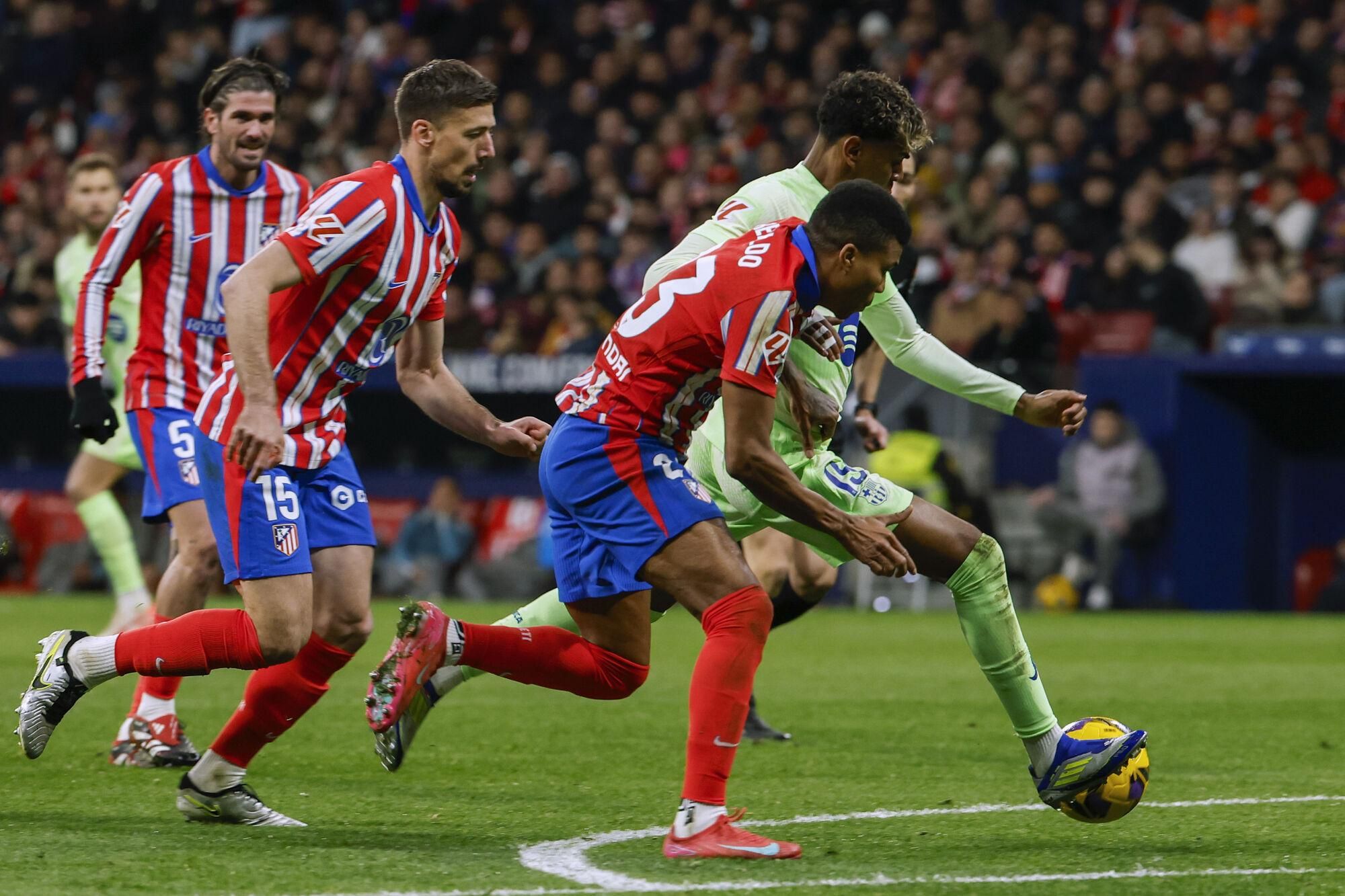 MADRID, 16/03/2025.- El delantero del FC Barcelona, Lamine Yamal (d), intenta llevarse el balón ante el centrocampista mozambiqueño del Atlético de Madrid, Reinildo Mandava, durante el encuentro correspondiente a la jornada 28 de Laliga EA Sports que disputan hoy domingo Atlético de Madrid y FC Barcelona en el estadio Metropolitano, en Madrid. EFE / J.J.Guillen