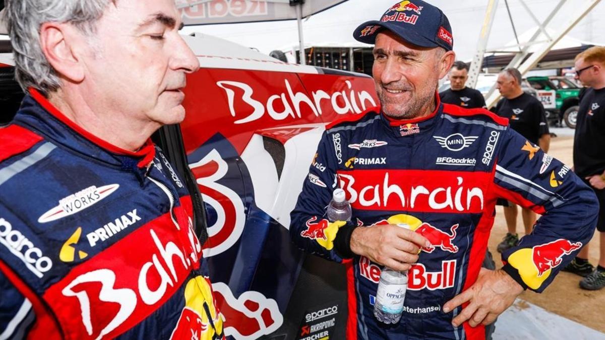 Stephane Peterhansel, a la derecha, habla, feliz, con un agotado Carlos Sainz.