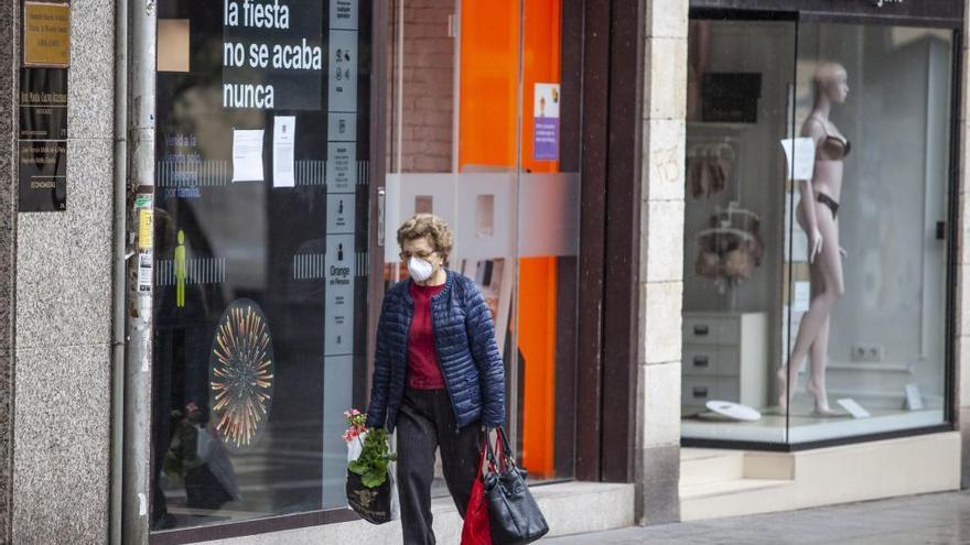 Una mujer protegida con mascarilla camina por el centro de Zamora.