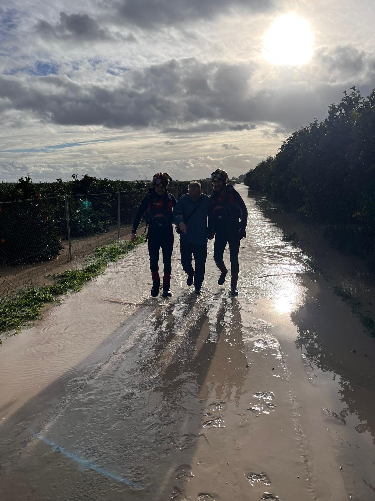 Los bomberos acompañan a uno de los rescatados en Palma del Río.
