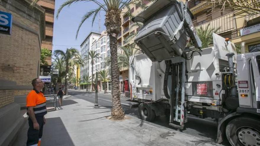 Operarios vaciando contenedores de basura en la recogida especial de la tarde en la zona del Mercado Central, ayer.