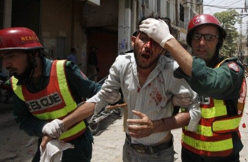 Rescue workers assist an injured supporter of Muhammad Tahirul Qadri, Sufi cleric and leader of political party Pakistan Awami Tehreek, during a protest in Lahore