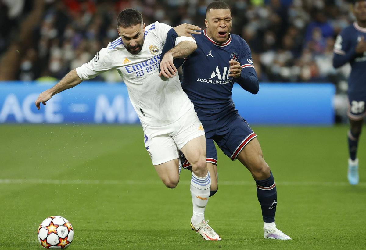 MADRID, 09/03/2022.- El defensa del Real Madrid, Dani Carvajal (i), disputa el balón ante el delantero del PSG, Kylian Mbappé, durante el encuentro correspondiente a la vuelta de los octavos de final de la Liga de Campeones que disputan hoy miércoles en el estadio Santiago Bernabéu, en Madrid. EFE / Juanjo Martín.