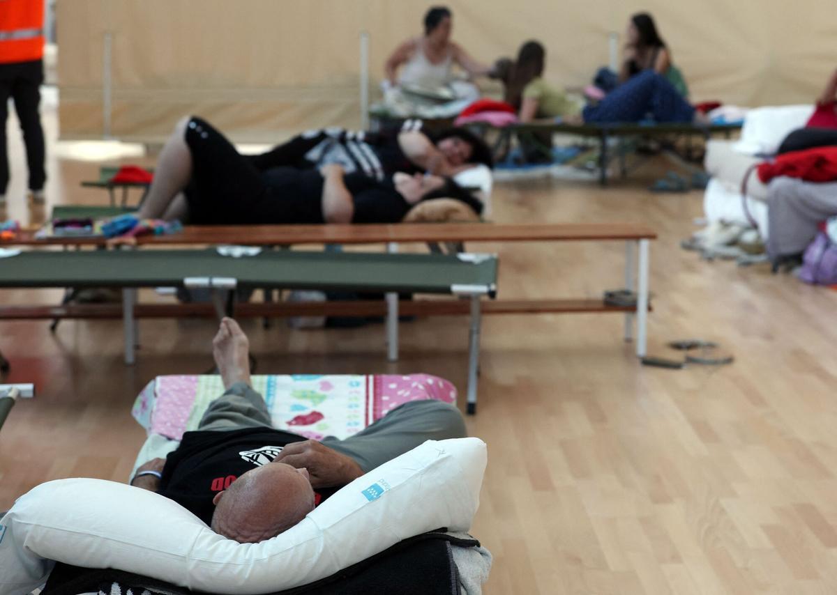 Evacuados de un incendio forestal intentan descansar mientras se refugian en el centro deportivo La Marazuela en Las Rozas de Madrid, el 27 de julio de 2026.