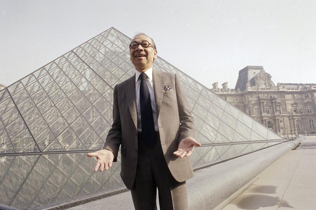 FILE - In this March 29  1989  file photo  Chinese-American architect I M  Pei laughs while posing for a portrait in front of the Louvre glass pyramid  which he designed  in the museum s Napoleon Courtyard  prior to its inauguration in Paris  Pei  the globe-trotting architect who revived the Louvre museum in Paris with a giant glass pyramid and captured the spirit of rebellion at the multi-shaped Rock and Roll Hall of Fame  has died at age 102  a spokesman confirmed Thursday  May 16  2019   AP Photo Pierre Gleizes  File