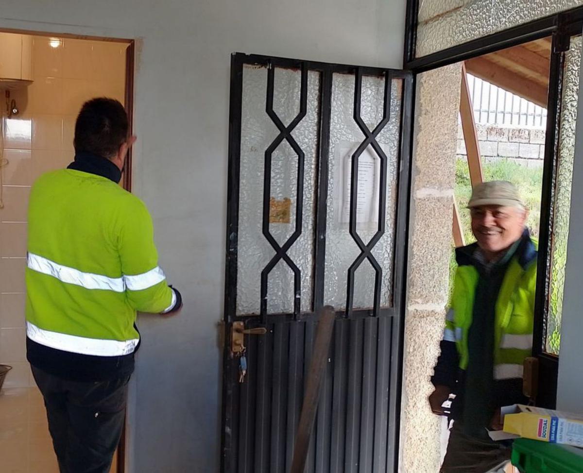 Operarios trabajan en el cambio de las puertas del edificio. |