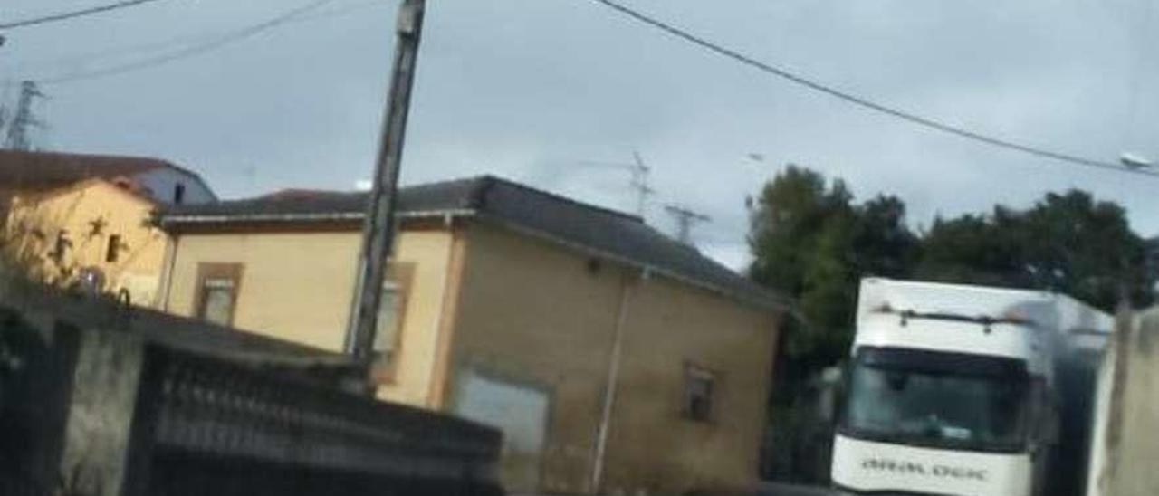 La &quot;casa rotonda&quot; de Noreña, con un camión aparcado al lado, en dirección contraria.