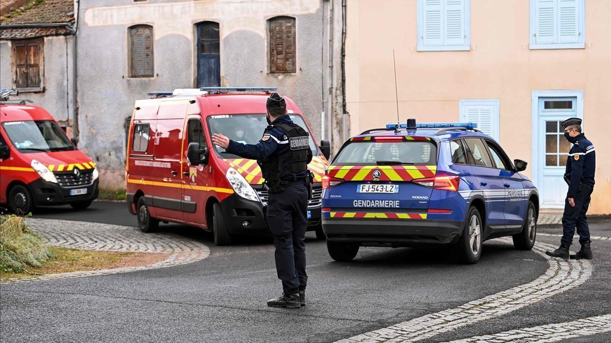 A French Gendarme gestures as fire-fighters trucks drive by in Saint-Just  central France on December 23  2020  after three gendarmes were killed and a fourth wounded by a gunman they confronted in response to a domestic violence call  - The suspect  a 48-year-old man known to authorities for child custody disputes  was  discovered dead  several hours after fleeing the home in an isolated hamlet near Saint-Just  a village south of the city of Clermont-Ferrand  Interior Minister Gerald Darmanin said in a tweet  (Photo by OLIVIER CHASSIGNOLE   AFP)
