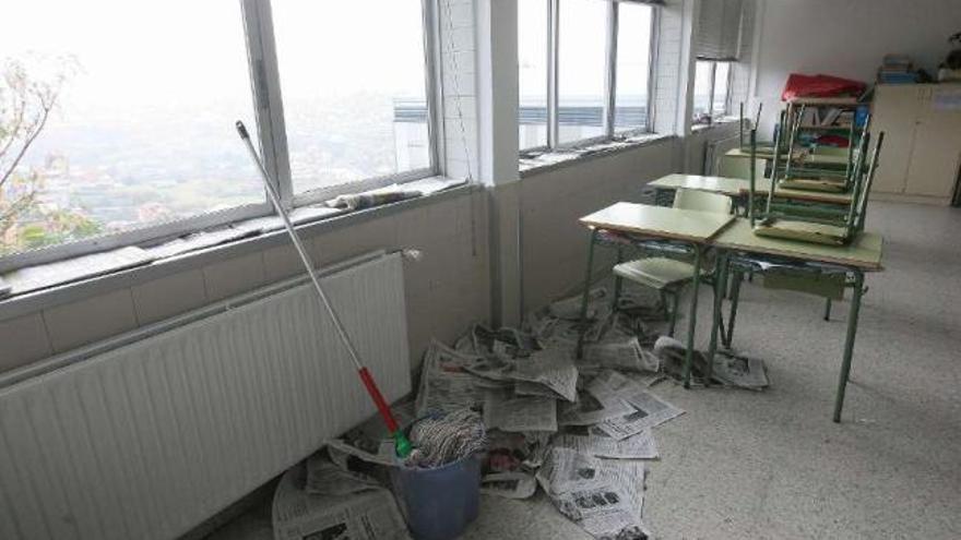 Periódicos taponan las filtraciones de agua en ventanas del colegio San Salvador.  // Fotos de Ricardo Grobas