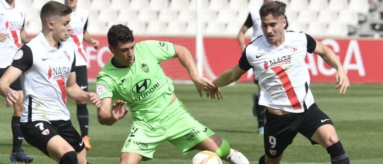 Zabarte protege el balón ante la presión de dos rivales del Sevilla Atlético.