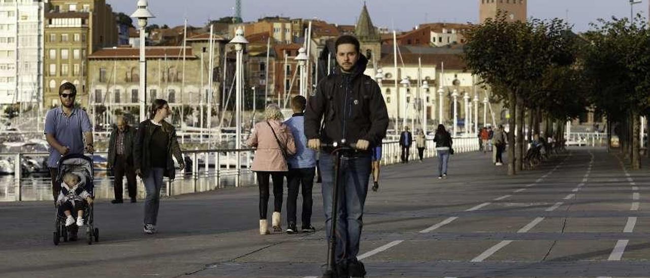 Un joven utiliza un vehículo de movilidad personal en Gijón.