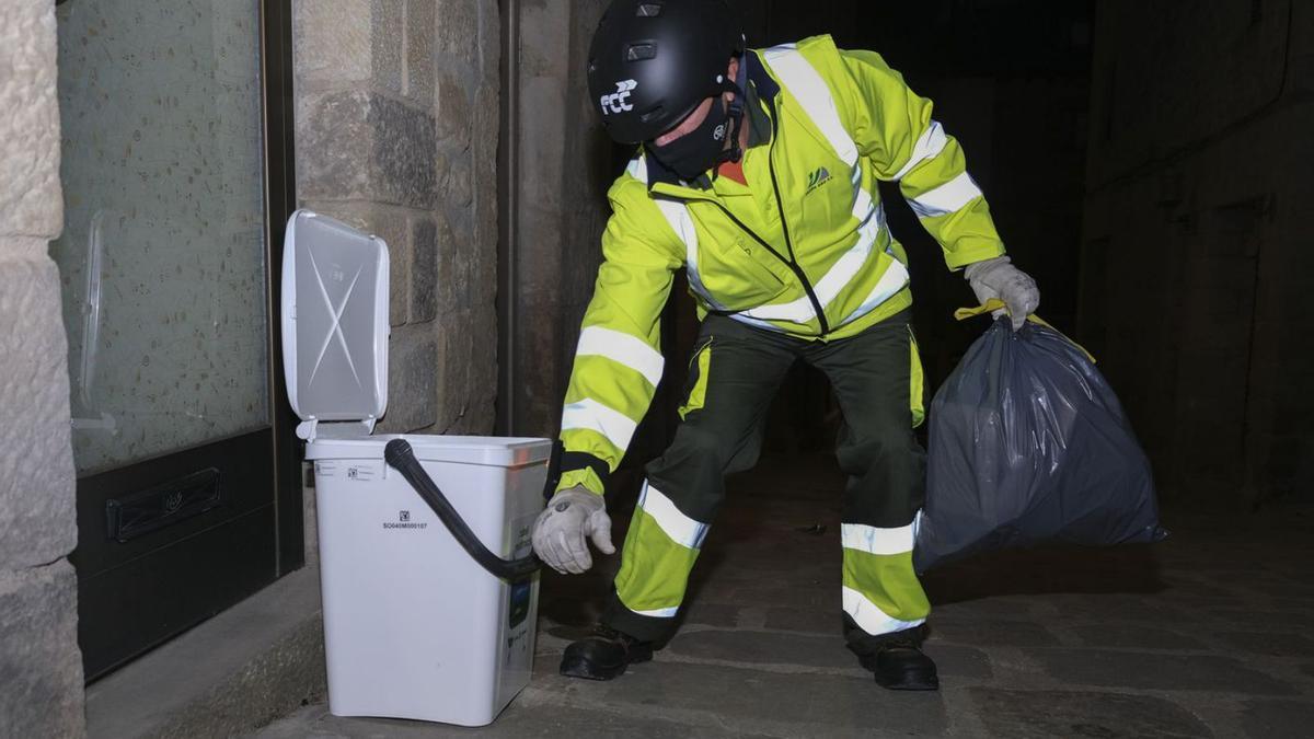 Un dels treballadors recull una bossa de deixalles durant el porta a porta de Solsona