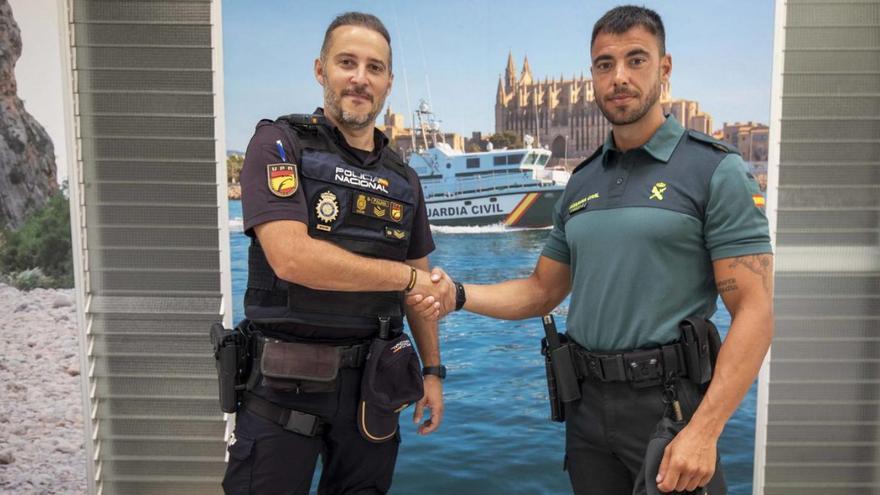 El policía nacional Juan Cedrún y el guardia civil Aitor García se estrechan las manos.