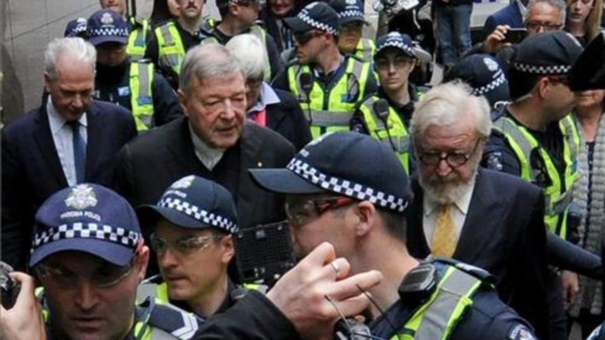 El cardenal George Pell (en el centro) sale de la Audiencia, en Melbourne.