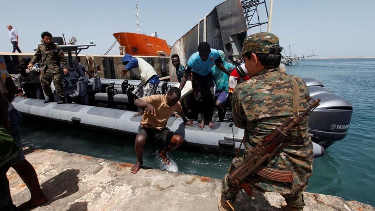 Inmigrantes llegan a la base naval libia después de haber sido rescatados por guardacostas libios en la costa de Trípoli.