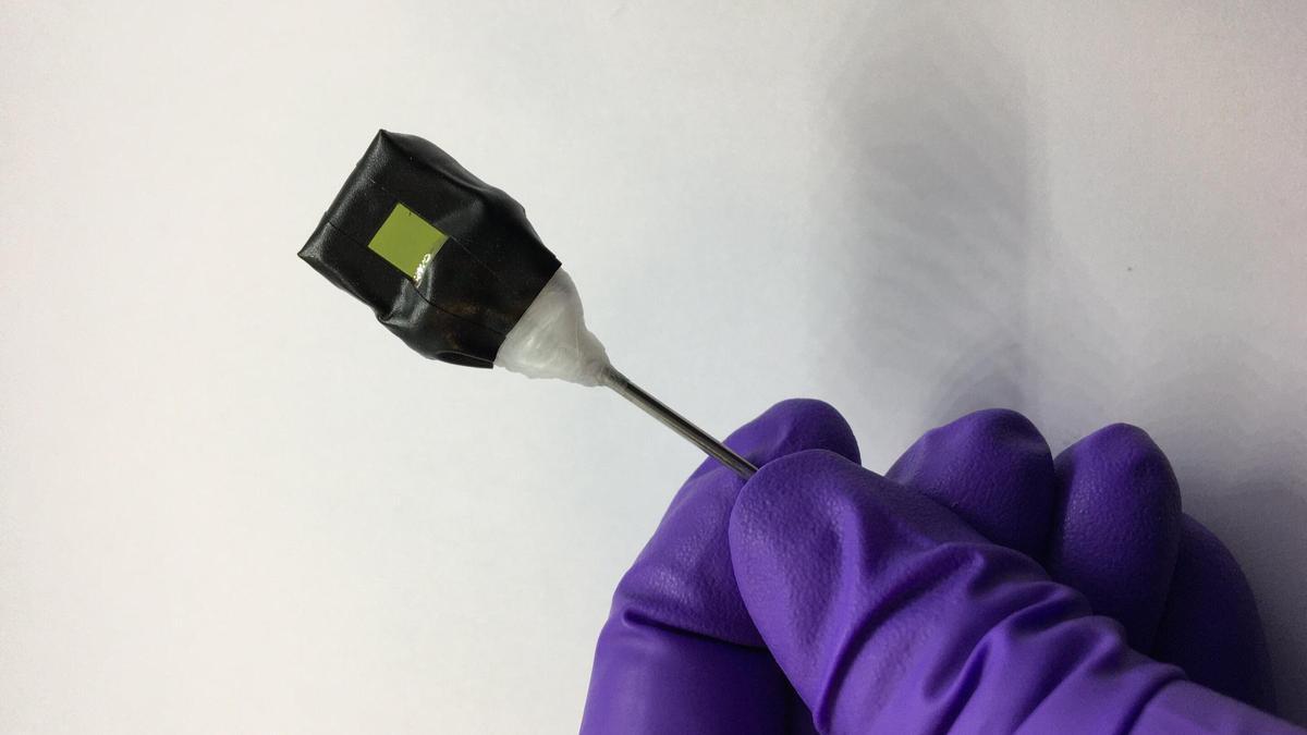 Una hoja artificial. El lado del fotoánodo (cuadrado verde) es visible en la fotografía.