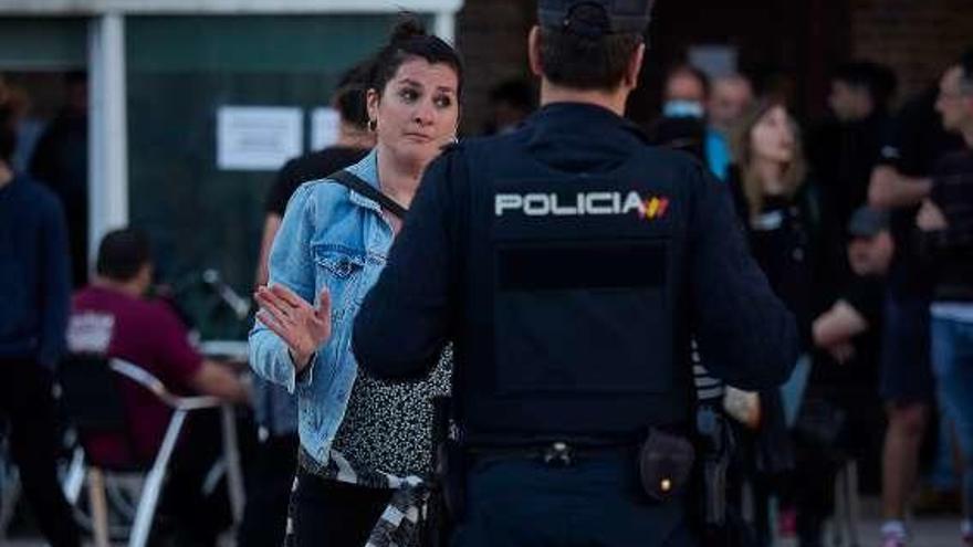 Un policía se dirije a una transeúnte sin mascarilla. // E. Sanz