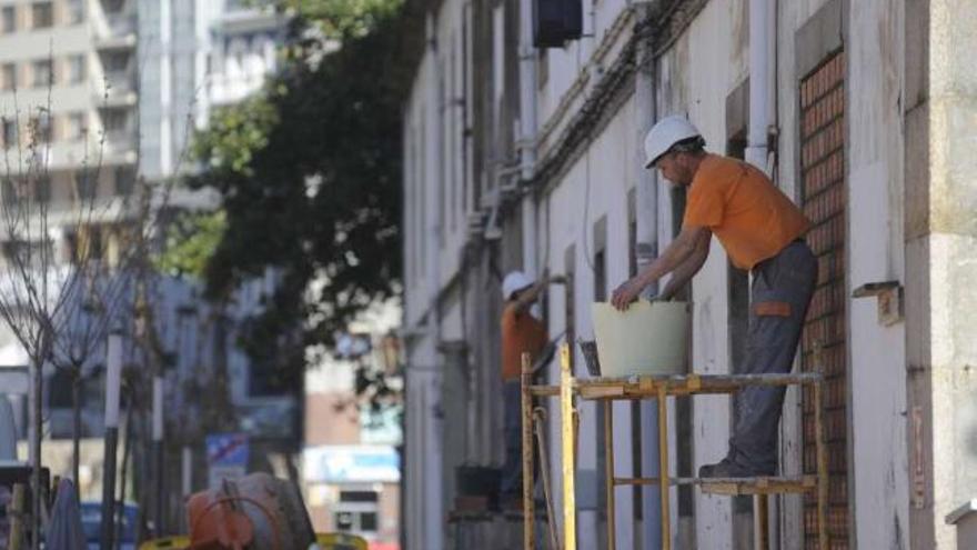 Dos operarios tapian las ventanas de la Fábrica de Tabacos, ayer por la mañana. / carlos pardellas