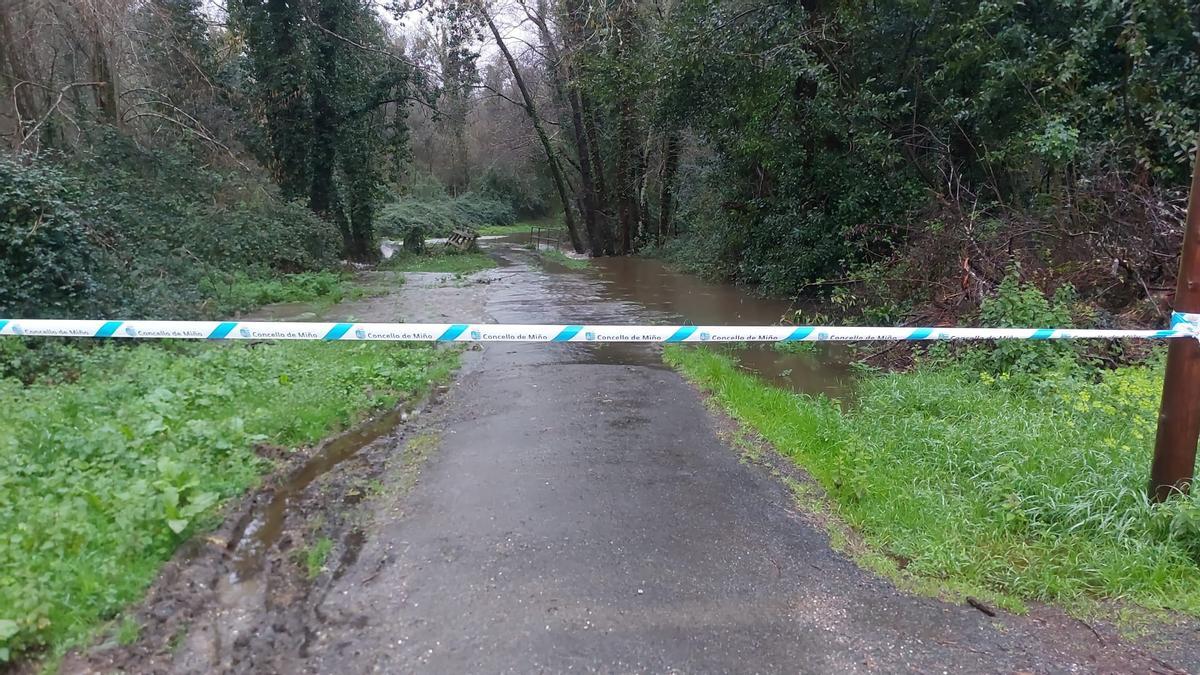 Carretera cortada en Miño por las inundaciones.