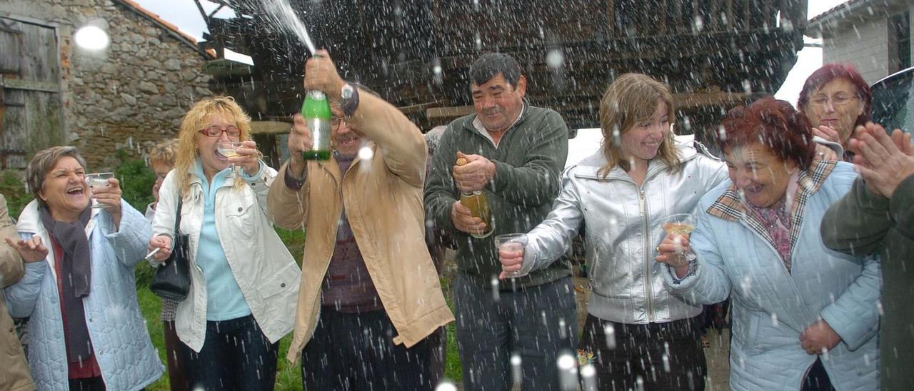 Vecinos de Molleo, celebrando el Gordo de 2007 con sidra y cava. | Luisma Murias