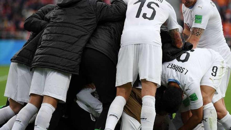 Los jugadores uruguayos se abalanzan sobre Giménez para celebrar su agónico gol a Egipto. // AFP