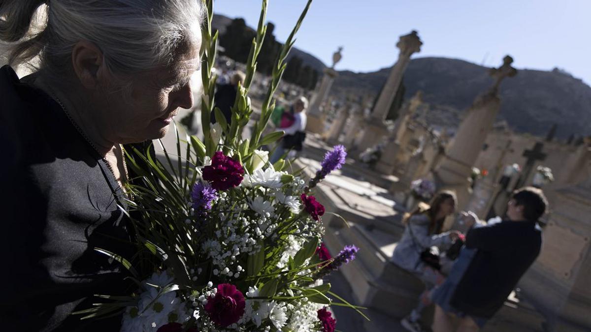 Una mujer sujeta un ramo de flores en el cementerio de Los Remedios en Cartagena.