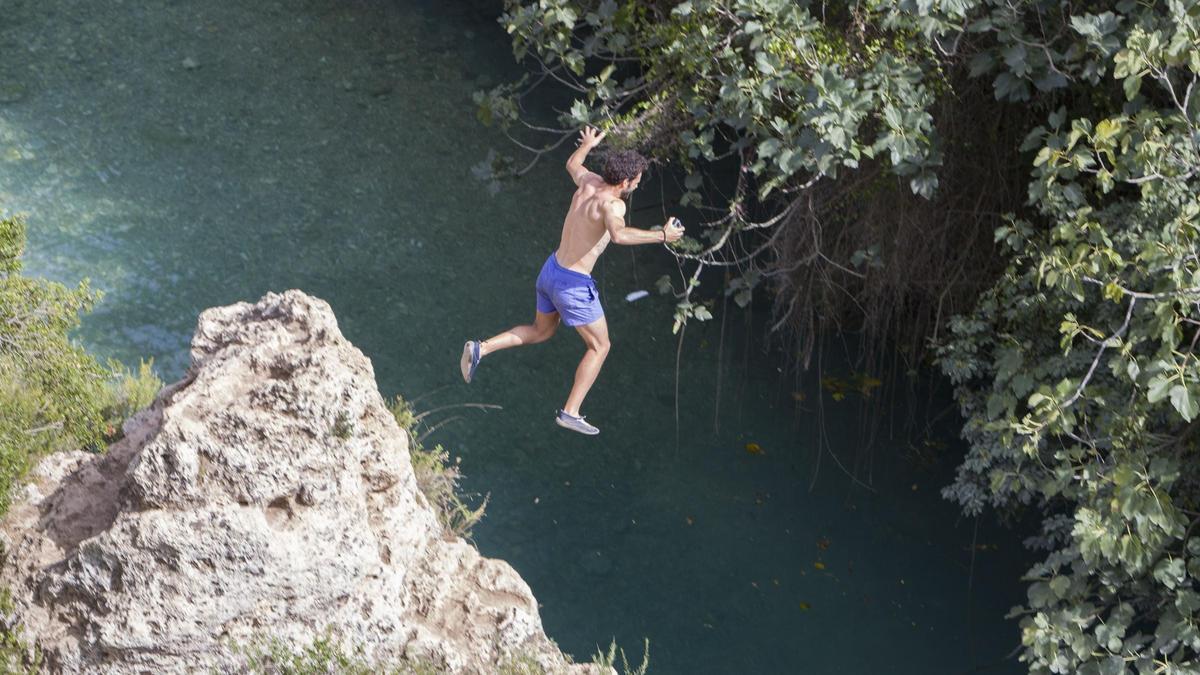 Un bañista se lanza desde una roca en el Gorgo de la Escalera de Anna.