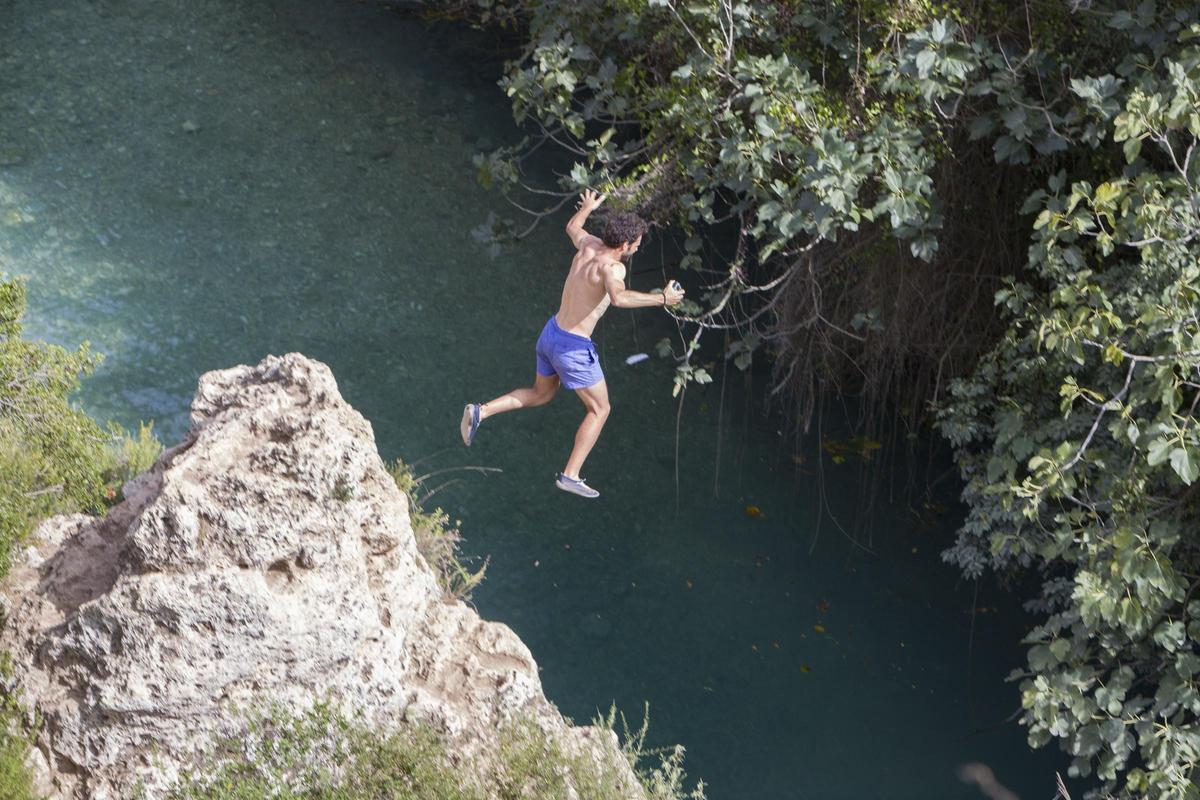 Un bañista se lanza desde una roca en el Gorgo de la Escalera de Anna.