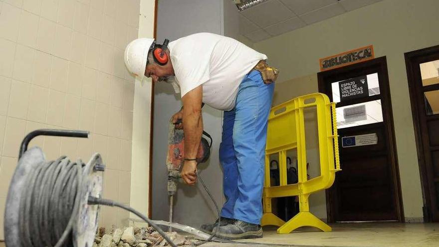 Un operario pica el suelo ubicado en la entrada del instituto. // Bernabé/Javier Lalín